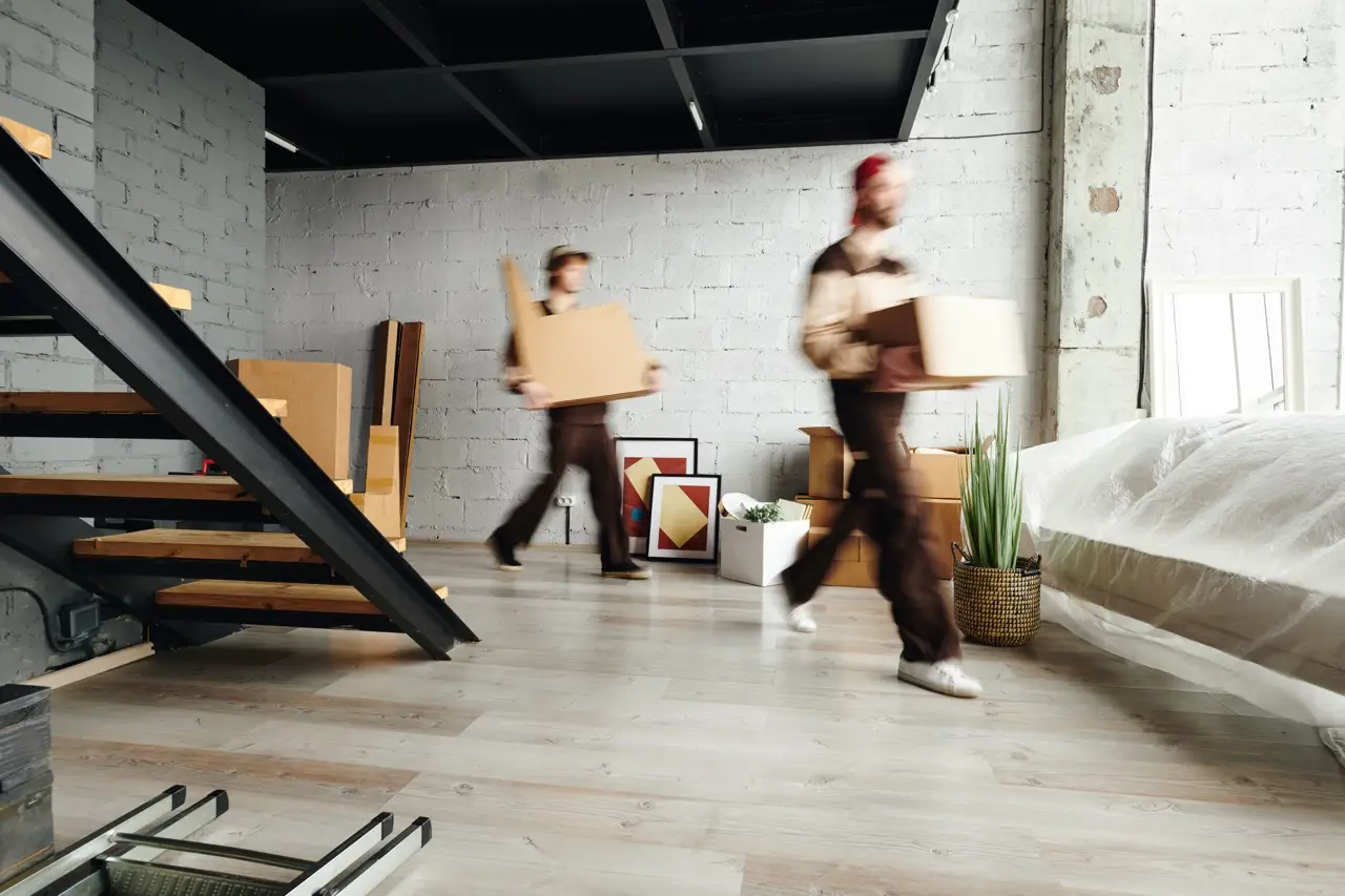 Moving team members carrying boxes in a modern interior, emphasizing efficient and professional relocation services in Vienna by Kraftpack.