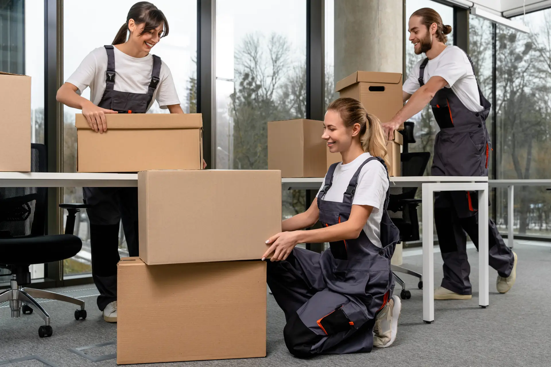 Young professionals packing moving boxes in an office setting, showcasing teamwork and organization, relevant to Kraftpack's moving and logistics services in Vienna.